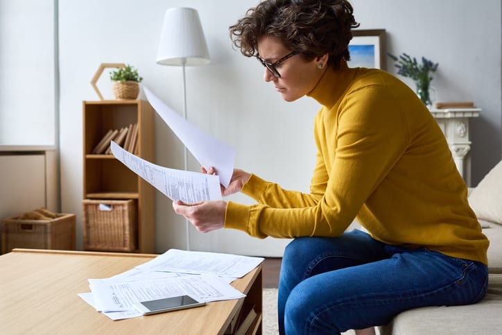 Law Office of Tipton-Downie | Attorney at Law | Vidalia, GA | Concentrating woman reviewing financial documents at home